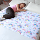 Child sleeping on a bed with the rainbow designed waterproof mattress protector
