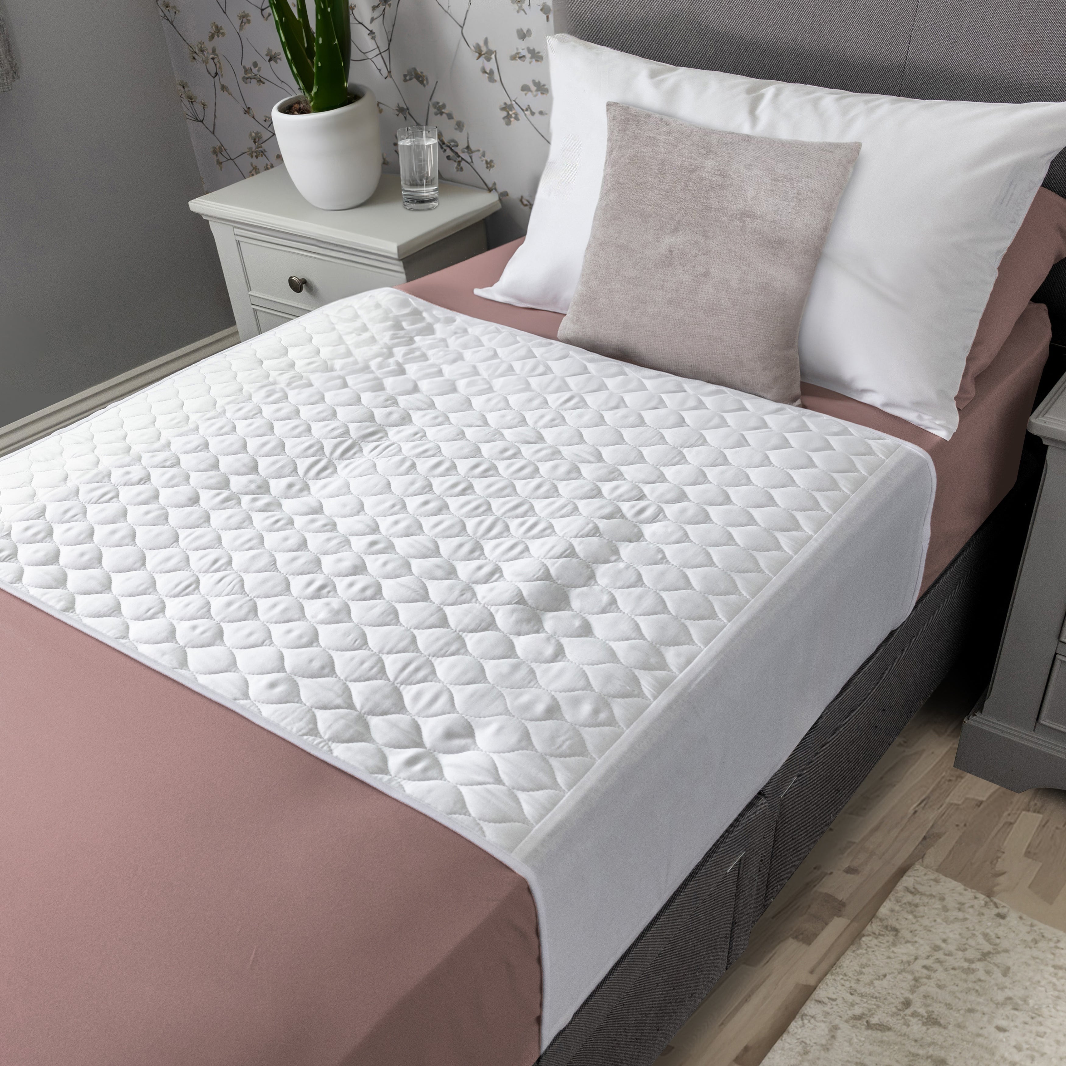 White organic bamboo mattress protector on a bed in a bedroom setting.