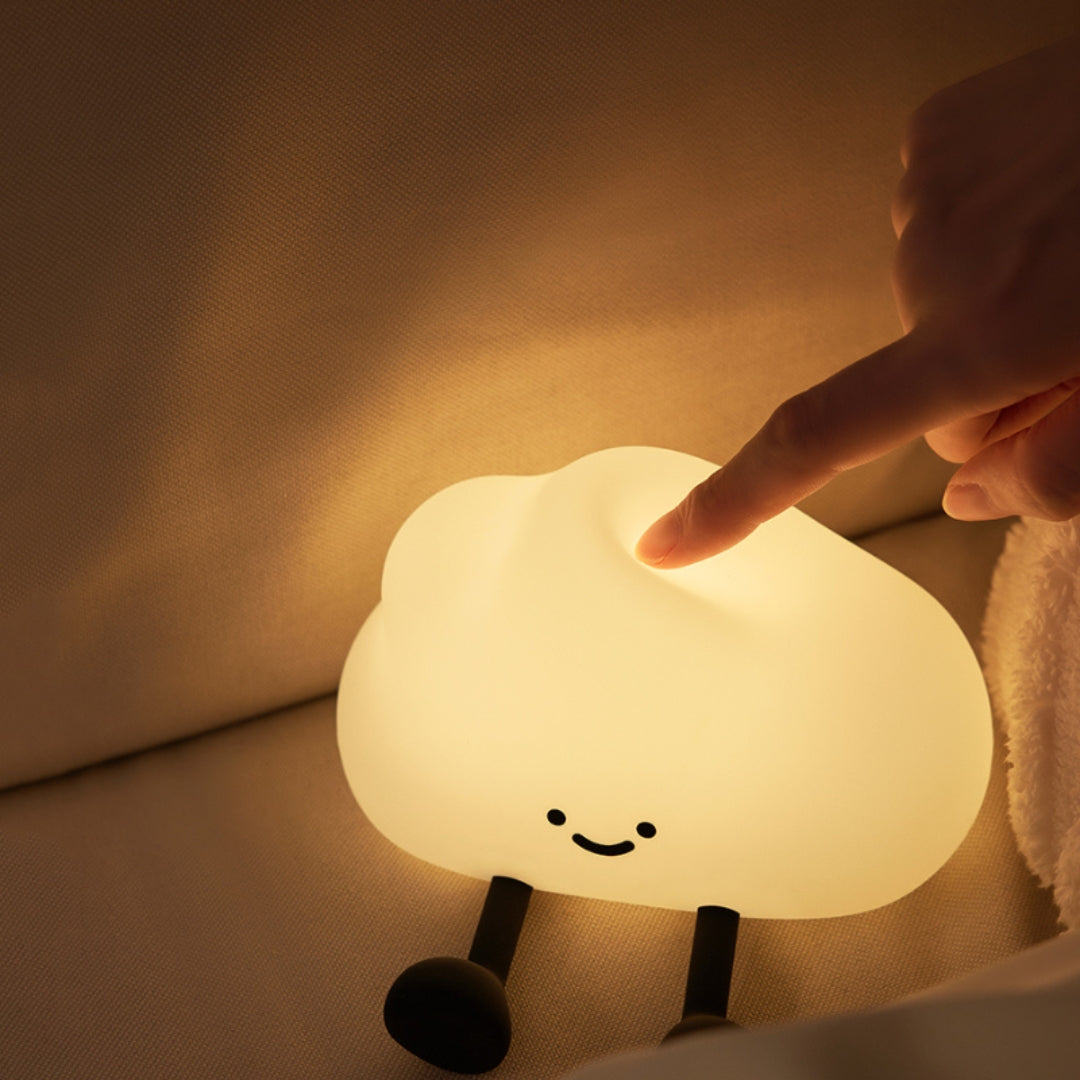 Cloud-shaped night light being touched by a hand in a warm setting