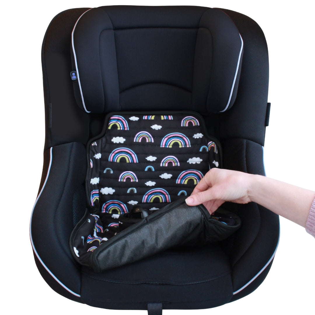 Black car seat with a rainbow patterned car seat protector being placed inside by a hand.