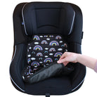 Black car seat with a rainbow patterned car seat protector being placed inside by a hand.